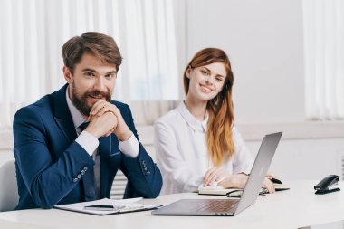 Erkek ve kadın yöneticiler dizüstü bilgisayarın önünde profesyonel teknolojinin önünde konuşuyor.