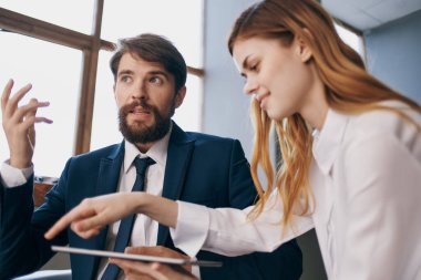 İş adamı ve kadın tablet yetkilileriyle birlikte çalışıyor.