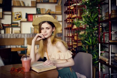 Kafe tarzında bir içkiyle masada oturan güzel bir kadın.