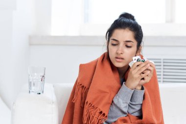 Ev tedavisinde battaniyeyle kaplanmış nezle olmuş bir kadın.