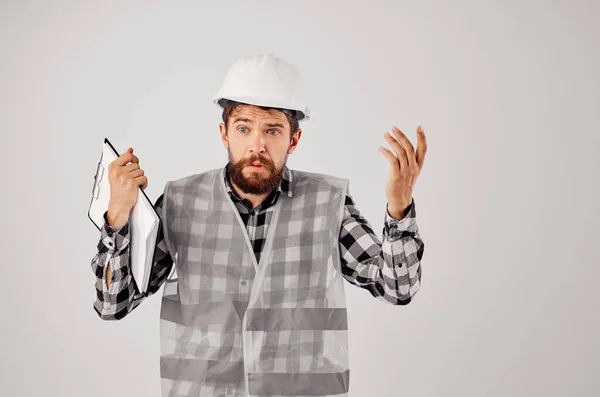 Mannelijke bouwer in een witte helm blauwdrukken Professionele lichte achtergrond — Stockfoto