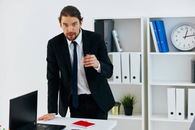 Ofiste takım elbiseli bir adam var. Hayat tarzı belgeli.