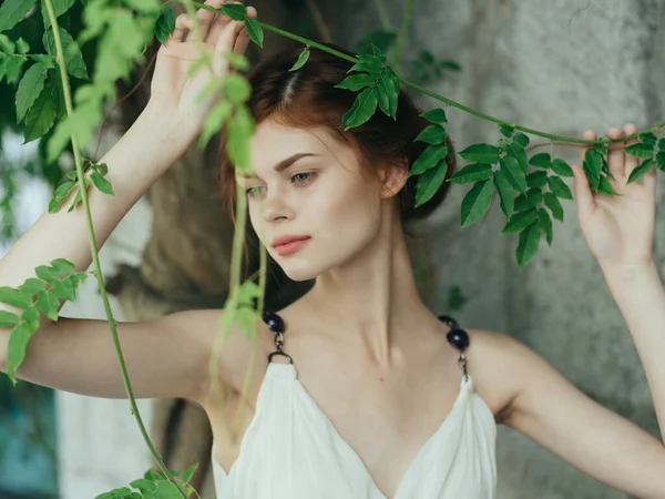 Bonita mulher no parque perto de árvore pedra parede posando mitologia — Fotografia de Stock