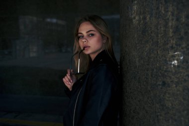 Güneş gözlüklü şık bir kadın yaz yürüyüşü pozu veriyor.