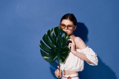 Mavi arka planda yaprağı olan güzel bir kadın. Yüksek kalite fotoğraf