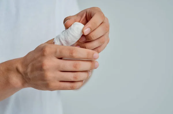 Paciente masculino con una camiseta blanca con una medicina de hospital de mano vendada —  Fotos de Stock