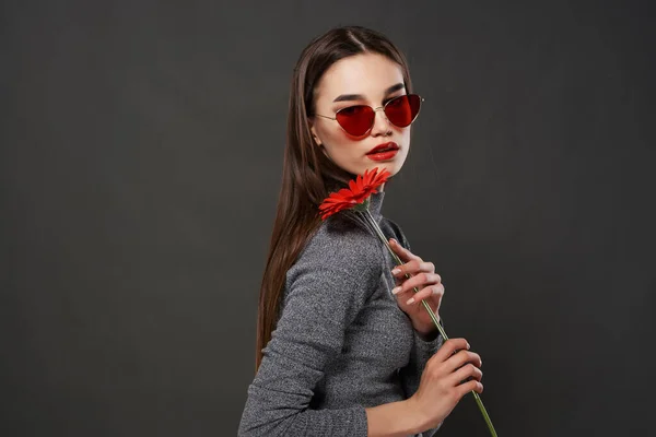 Güneş gözlüğü takan çekici esmer, kırmızı çiçek romantizmi makyajı yapan. — Stok fotoğraf