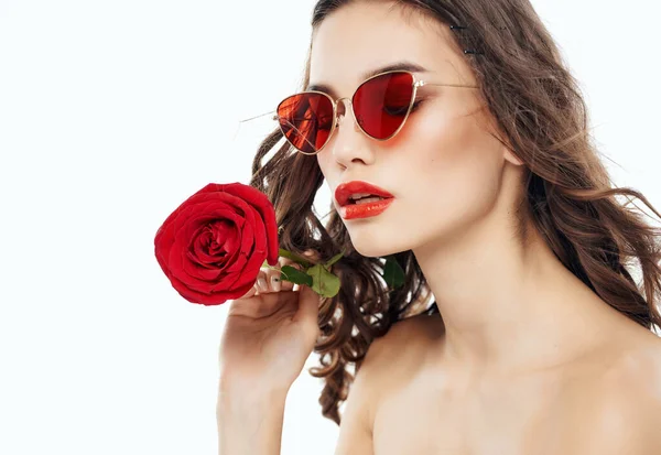 Csinos nő napszemüvegben egy rózsával a kezében meztelen vállak — Stock Fotó