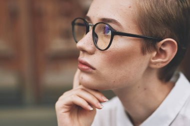 Elinde kitapla dışarıda Yaşam Tarzı okuyan bir öğrenci.