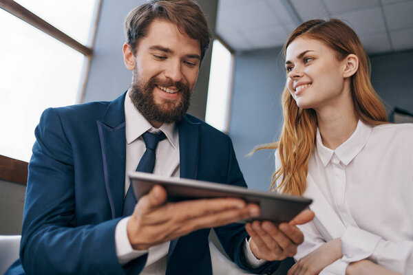 man and woman in business suits work with a tablet managers professionals