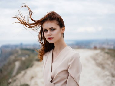 Kum yaşam tarzında kayaların yanında poz veren bir kadın.