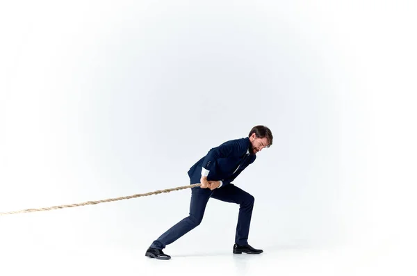 A man in a suit pulls the rope emotion work office — Stock Photo, Image