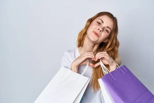 Veselá žena v bílém tričku nakupování pestrobarevné tašky Shopaholic — Stock fotografie