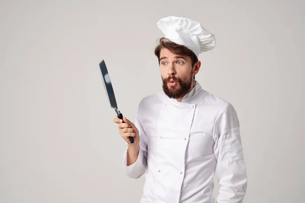 Vousatý muž kuchař s pánví smažení v ruce světlé pozadí — Stock fotografie