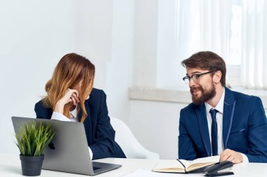 Laptop ofis teknolojisinin önünde masada oturan meslektaşlarım.