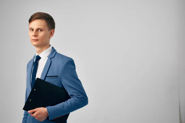 Homme dans un costume avec des documents dans ses mains fond de lumière de bureau professionnel — Photo