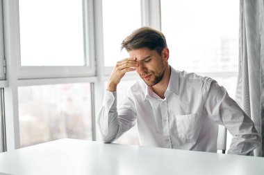 Ofisteki masada oturan şaşkın adam. 