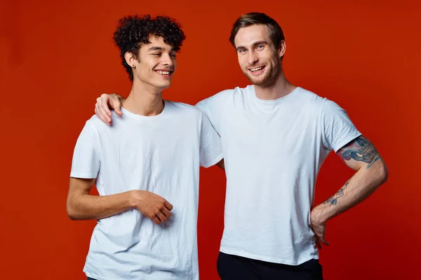 Divertido dos amigos en blanco camisetas posando estudio — Foto de Stock