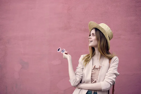 Mujer en la calle con sombrero y gafas modelo de pared rosa — Foto de Stock