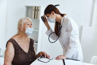 Doktor sağlık hizmetlerindeki yaşlı kadın hasta.