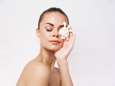 Güzel kadın, çıplak omuzlar, kapalı gözler, izole edilmiş beyaz çiçek.