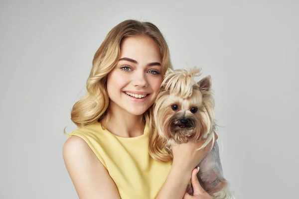 blonde in a yellow dress fun a small dog cropped view fashion