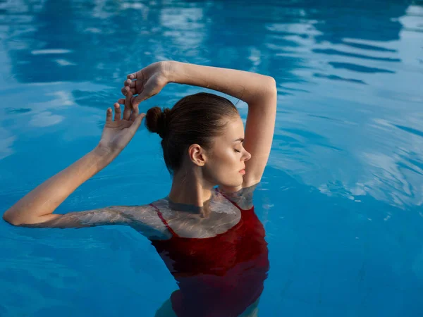 Mujer en traje de baño rojo en la piscina ojos cerrados gesto de reposo con las manos —  Fotos de Stock
