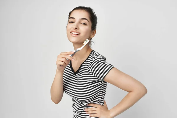 Morena escovar os dentes com uma escova de dentes isolado fundo — Fotografia de Stock
