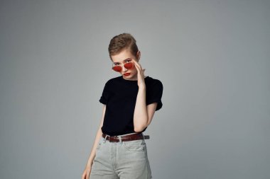 Kısa saçlı, güneş gözlüklü, izole bir geçmişi olan bir kadın.