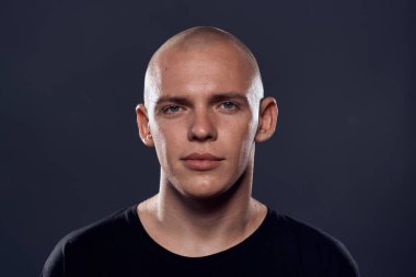 Siyah kazaklı kel kafalı neşeli bir adamın yakın çekimi.