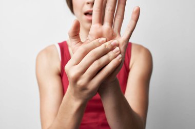 Kırmızı tişörtlü kadın, eklem ağrısı, el tedavisi.