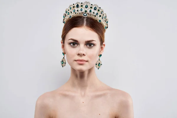Ritratto di una donna con una corona sul suo modello di trucco testa isolato sfondo — Foto Stock