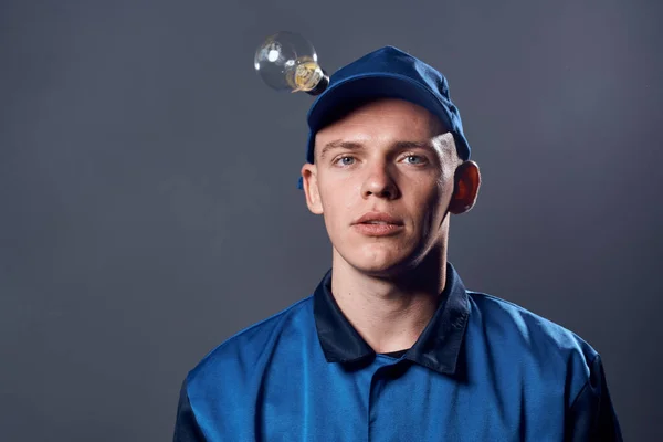 Homem em trabalhar uniforme eletricista ferramentas de lâmpada profissional — Fotografia de Stock