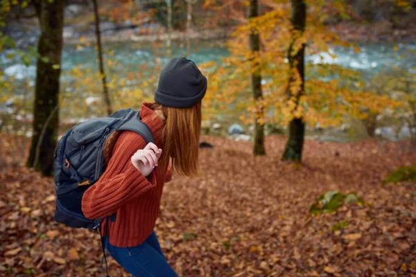 Vrouw met rugzak reizen in de herfst bos — Stockfoto