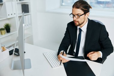 Takım elbiseli bir adam cep telefonuyla iletişim halinde.