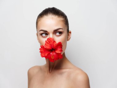 Çıplak omuzlu bir kadın. Kırmızı çiçek desenli.