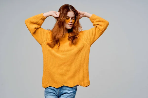 Bonita mujer en un suéter amarillo gafas de moda modelo de estudio — Foto de Stock