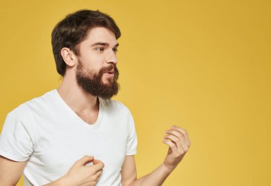 Beyaz tişörtlü duygusal adam hoşnutsuz görünüyor.