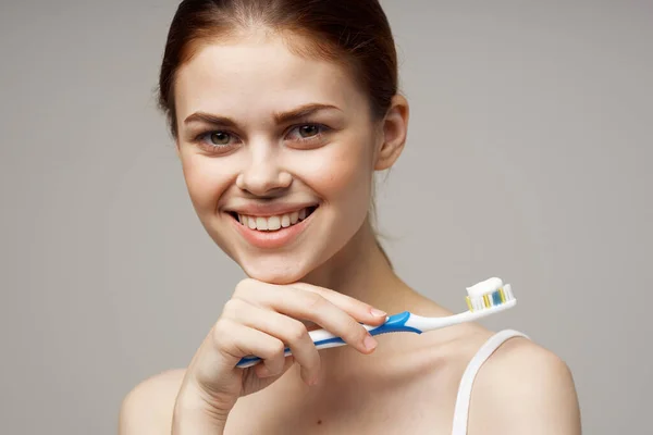 Pretty woman with a toothbrush in hand morning hygiene isolated background — Stock Photo, Image