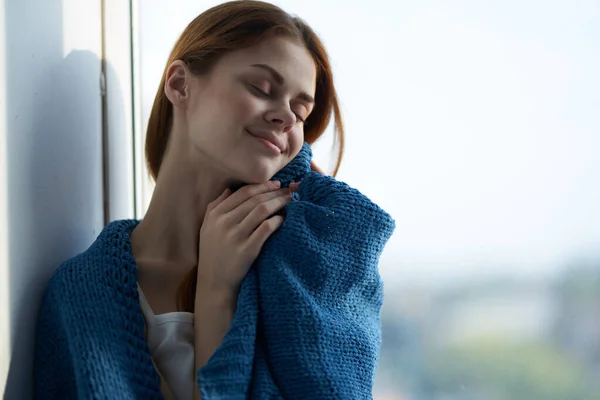 Γυναίκα κάθεται κοντά στο παράθυρο με ένα μπλε καρό ονειρικό βλέμμα — Φωτογραφία Αρχείου