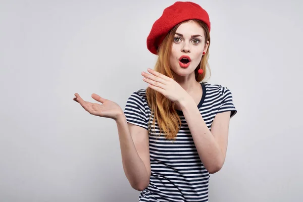 Femme gaie dans un t-shirt rayé rouge à lèvres geste avec ses mains fond isolé — Photo