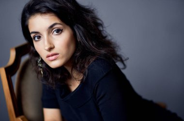 Koyu renk elbiseli güzel bir kadın izole bir arka plan oluşturuyor.