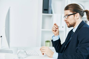 Masa başında takım elbiseli bir adam çalışıyor.