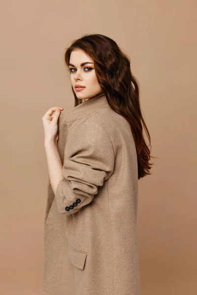 Sexy brunetka makijaż i beżowy płaszcz widok z boku — Zdjęcie stockowe