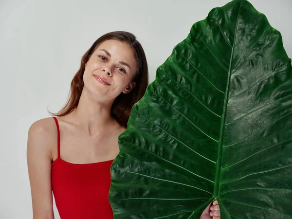 Temiz ciltli ve yeşil palmiye yaprağı açık arkaplanı olan bir kadın. — Stok fotoğraf