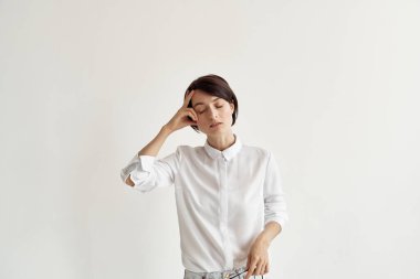 Gözlüklü, kendine güveni olmayan, beyaz gömlekli bir kadın.