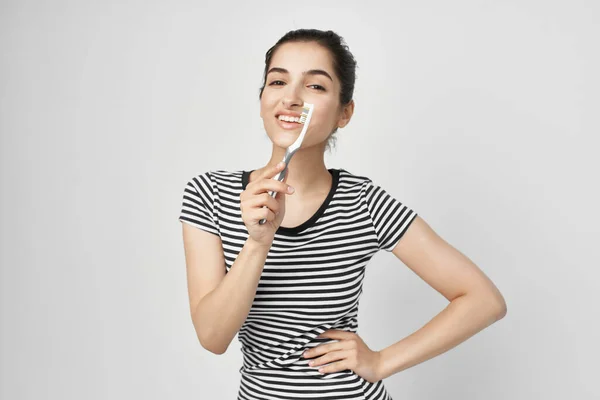 Μελαχρινή σε ριγέ T-shirt οδοντόβουρτσα στο χέρι απομονωμένη φόντο — Φωτογραφία Αρχείου