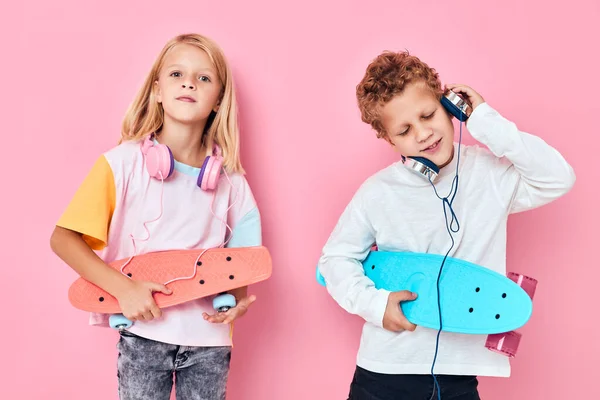 Lindo niños auriculares moda monopatines rosa fondo —  Fotos de Stock