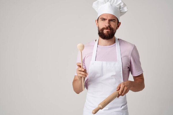professional chef in uniform with a spoon in his hands work light background