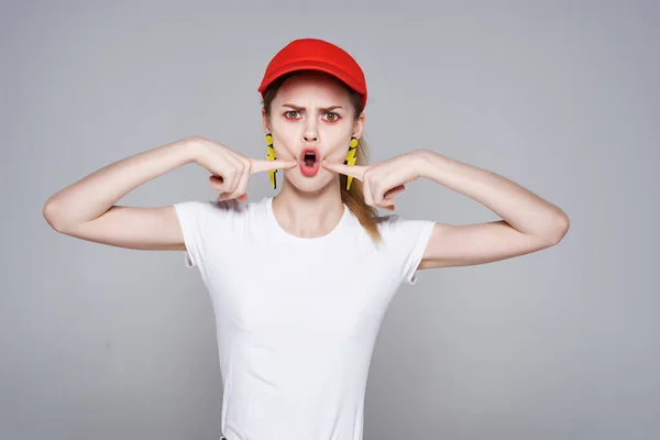 Emotionales Mädchen mit roter Mütze helles Make-up gelbe Ohrringe Schmuckaccessoires — Stockfoto